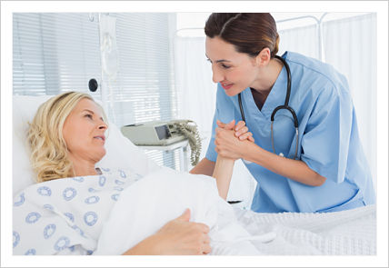 Female Nurse standing next to an expectant mother (lying in swing bed) while holding patient&apos;s hand