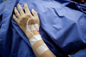 Patient lying on their back with an IV in their hand